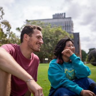 A group of students chatting while sitting on Globe Lawn on Kensington Campus