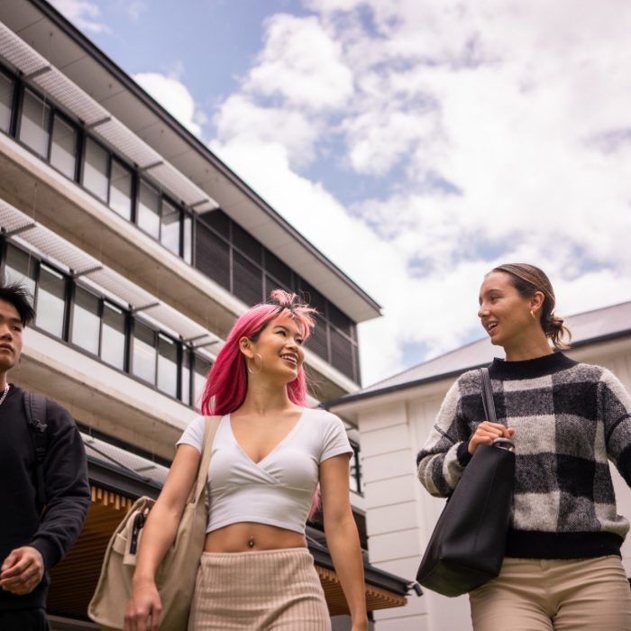 Three students chatting while walking outdoors on Paddington Campus