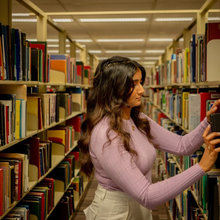 A student browsing the library shelves