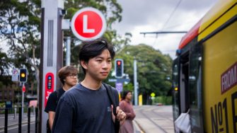 A student at the UNSW HIgh Street light rail stop