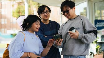 Students looking at one of their phones on campus