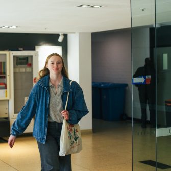 Photo of a student walking through a building on campus