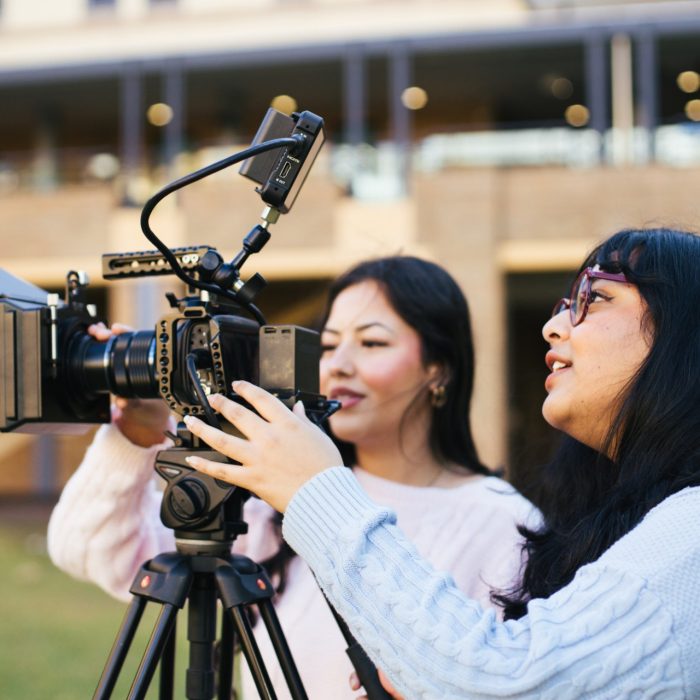 Students using video equipment on Helen Maguire Lawn