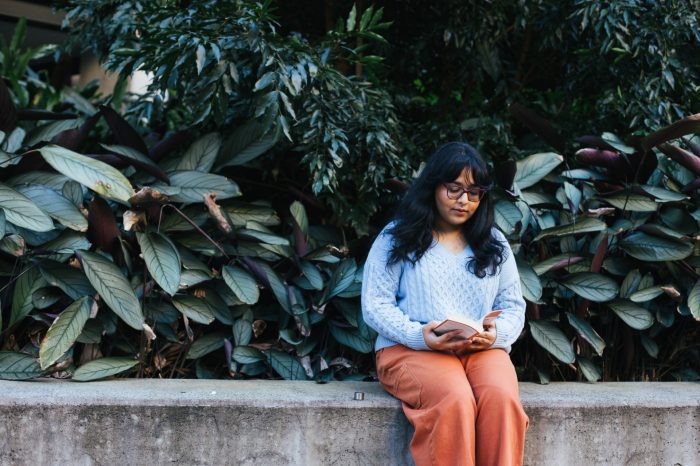 Photo of a student reading on campus