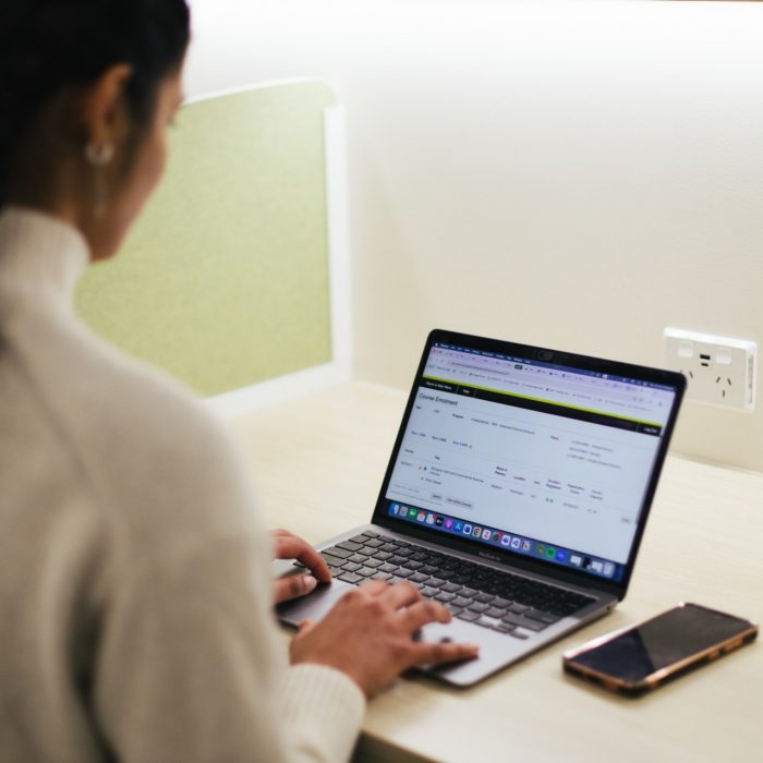 Student at a desk using their laptop to enrol on myUNSW