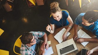 High angle shot of a group of students studying in a coffee shop