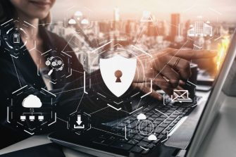 person at laptop with security graphic