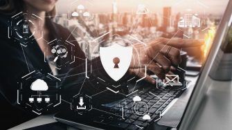 person at laptop with security graphic