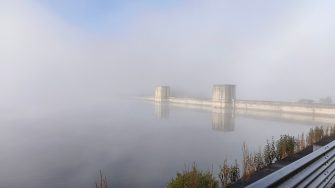 Cordeaux dam wall in mist with road barrier in front