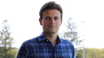 Dr Bojan Tamburic wearing a blue checked shirt looking into the camera.