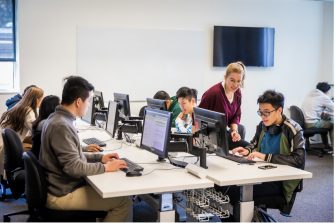 Students engaging in a hackathon at their computers in a classroom
