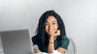 Woman smiling in front of laptop