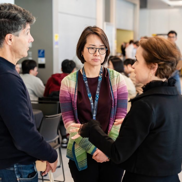 Three attendees talking together at the UNSW–UTS TDS Student Forum.
