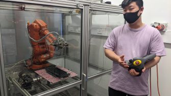 Person holding the controller to a robotic arm