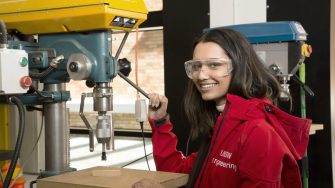 UNSW engineering student working with machinery wearing safety gear in workshop