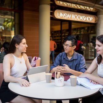 UNSW students sitting at a table outside the bookshop