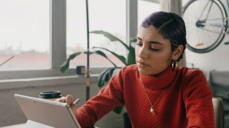 Person in red sweater using a laptop