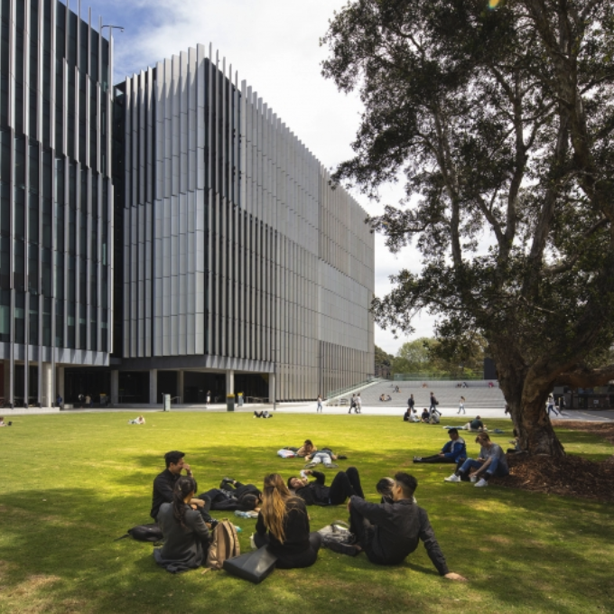 Students sitting on a lawn in front of the UNSW Science and Engineering Building.