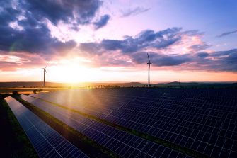 Solar panels park and wind turbines at sunset