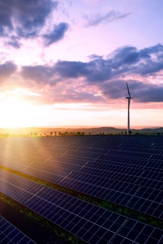Solar panels park and wind turbines at sunset