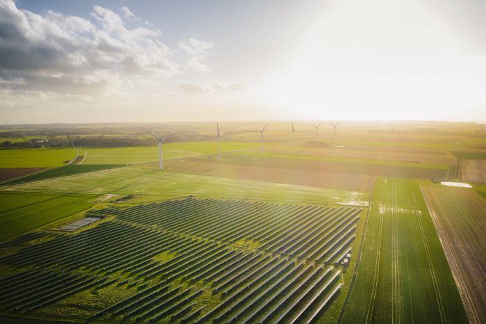 Wind turbines and solar panels farm in a field