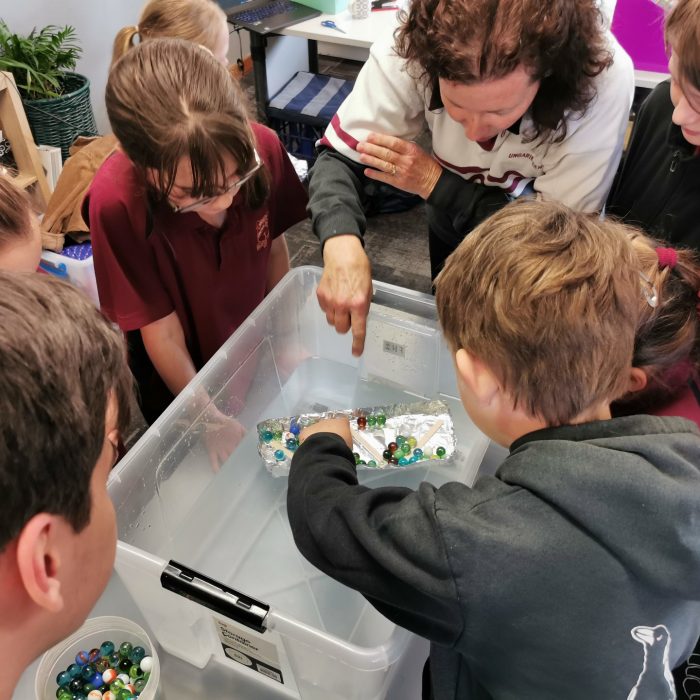 Students learning about engineering using marbles