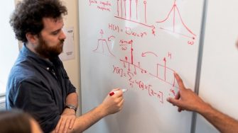 4 engineer students writing on whiteboard
