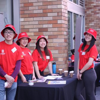 Four Engineering students wearing red outside