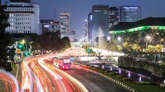 Traffic light trails along Jakarta main avenue in the business district at night in Indonesia capital city. The Transjakarta bus has its own traffic line to avoid the heavy congestion in the city.