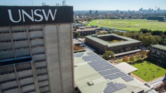 Aerial view of UNSW Kensington campus showing rooftop solar panels and the Sydney skyline.