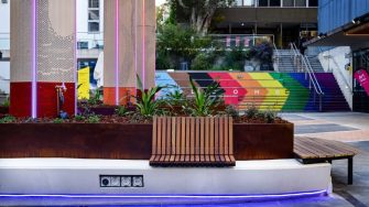 The upgraded UNSW Paddington campus courtyard with new planters, timber bench seating and a colourful staircase artwork.