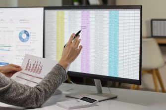 Businesswoman reviewing data on office monitor