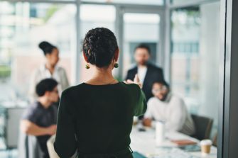 Woman meeting with team pointing to them and delegating