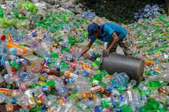 Waste worker collecting plastic bottles.