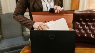 Brown suit woman grabbing files
