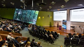 Students sitting in a lecture theatre watching a presentation