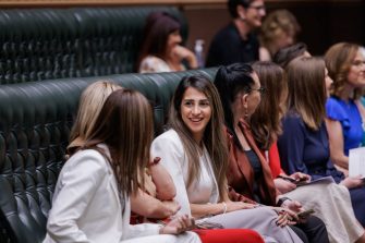 Women sitting on a bench inside Parliament house.