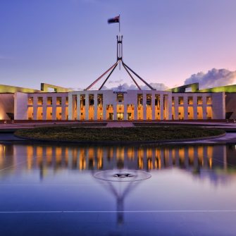 colourful reflection of Canberra's new parliament building in a fontain pond at sunset.