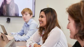 Students in Law PhD Room, around a table with laptops and tv screen