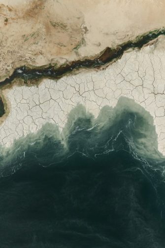 Aerial View of Cracked Earth Meeting Ocean- Desert Coastline
