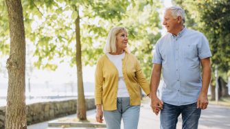 Senior couple walking along a tree-lined parkway