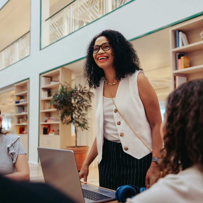 A diverse group of colleagues engaged in a collaborative meeting in a stylish and aesthetic workplace. The image captures the essence of teamwork, creativity, and a positive work environment in a modern office setting.