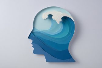 A papercraft human head silhouette filled with a calm, layered ocean wave. A powerful visual metaphor for mental health, calm, mindfulness, and psychology.