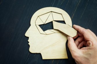 Memory loss and problems with brain. The hand puts the last piece of the puzzle.