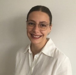 A photo of a young woman staring into the camera smiling