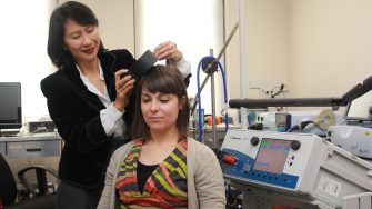 Woman using a brain scanning instrument on a patient
