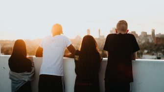 Four people looking at the city at sunset