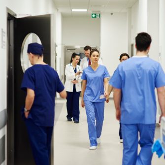 Hospital staff walking through ward