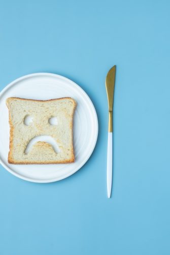 Doctor counselling male patient with abdominal pain in hospital examination room