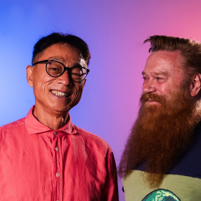Two people pose for the camera, the second person looking at the first.